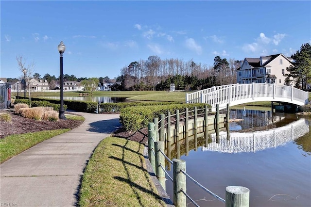 view of property's community with a water view and a yard