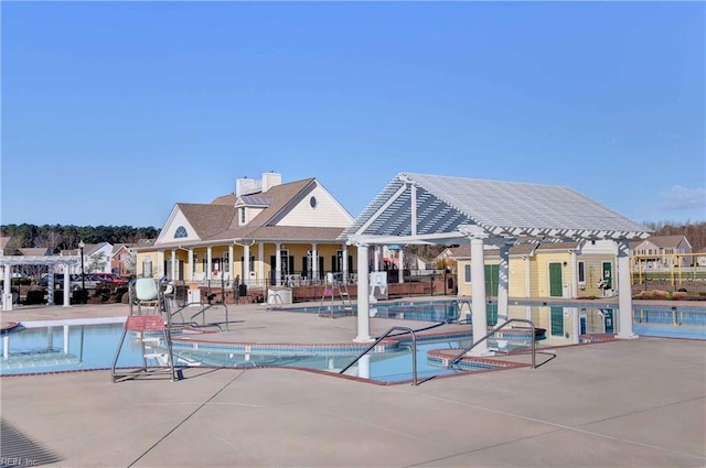 community pool with a pergola, fence, and a patio