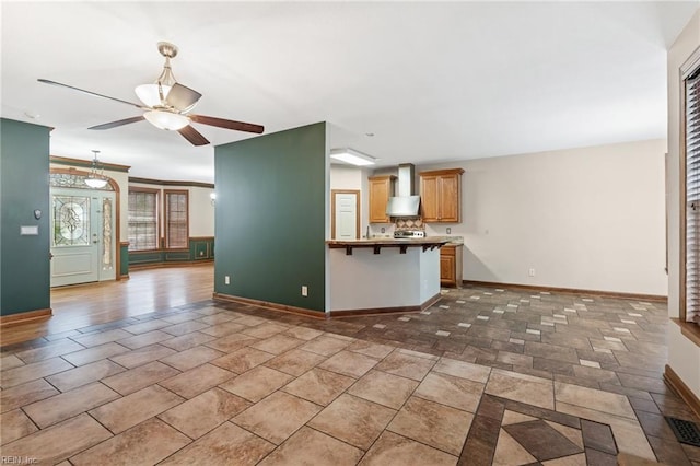 unfurnished living room featuring a ceiling fan and baseboards