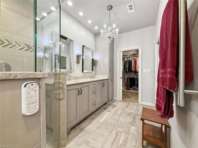 bathroom featuring visible vents, baseboards, a spacious closet, a shower stall, and double vanity