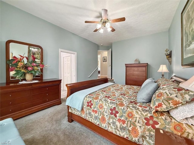 carpeted bedroom featuring ceiling fan and a textured ceiling