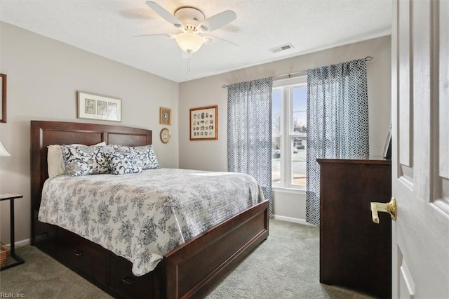 carpeted bedroom with a ceiling fan, visible vents, a textured ceiling, and baseboards