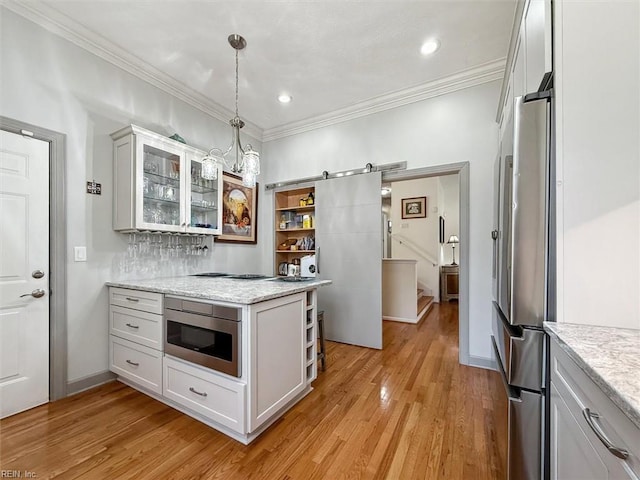 kitchen with light wood finished floors, open shelves, a barn door, and stainless steel appliances