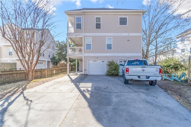 view of front of property featuring driveway, an attached garage, and fence