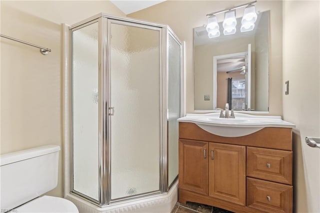 bathroom with toilet, a shower stall, and vanity