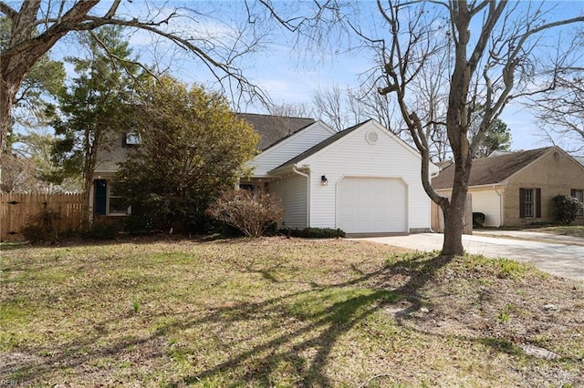 view of front of property featuring a front yard, driveway, an attached garage, and fence