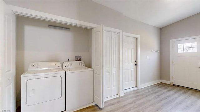 laundry room featuring baseboards, laundry area, light wood-style floors, and washer and dryer