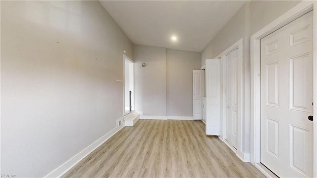 hall featuring light wood-style floors and baseboards