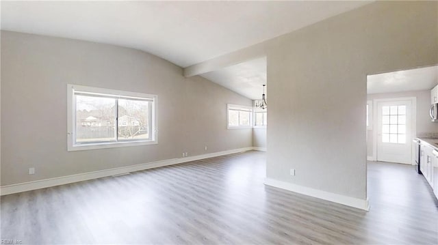 unfurnished living room with baseboards, vaulted ceiling, and wood finished floors