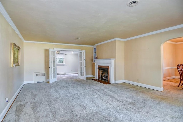 unfurnished living room with arched walkways, french doors, radiator, visible vents, and a baseboard heating unit