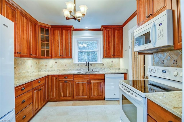 kitchen featuring light stone counters, white appliances, light tile patterned flooring, and a sink