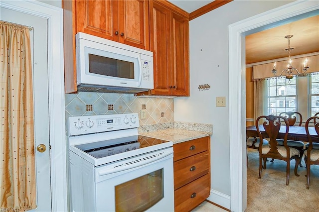 kitchen featuring brown cabinets, decorative backsplash, an inviting chandelier, light carpet, and white appliances