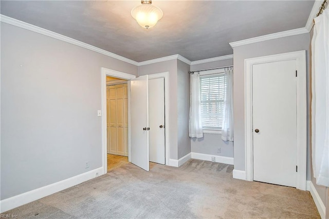 unfurnished bedroom with ornamental molding, carpet flooring, and baseboards