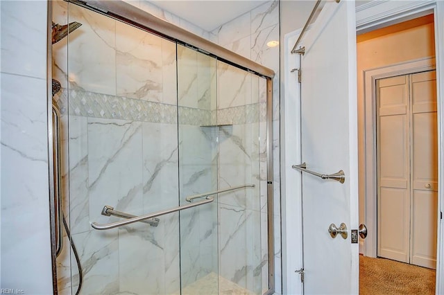 bathroom featuring a marble finish shower