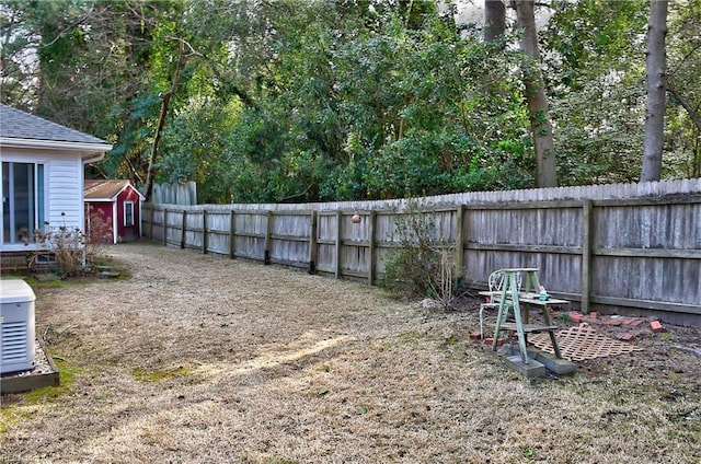 view of yard with an outbuilding, fence, and a storage shed