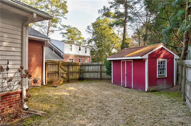 view of yard featuring an outbuilding, a fenced backyard, and a storage unit