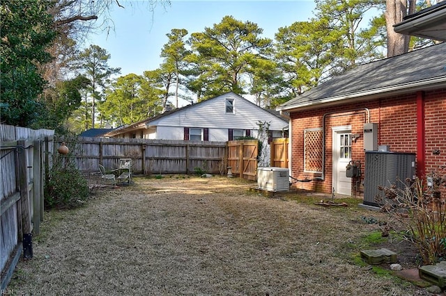 view of yard with central air condition unit and a fenced backyard