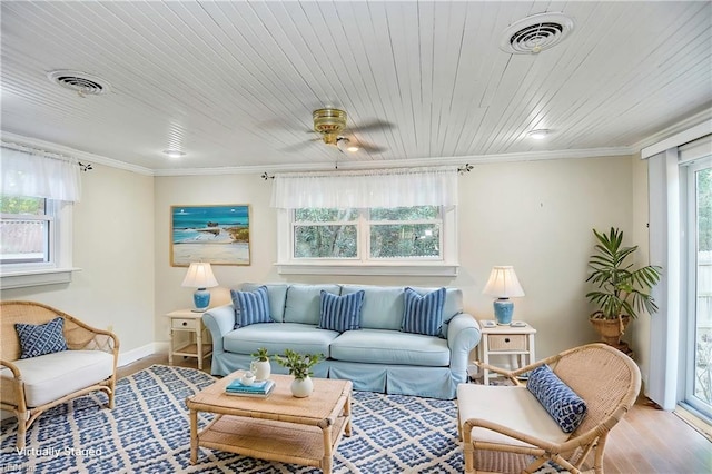 living area featuring visible vents, crown molding, and wood finished floors