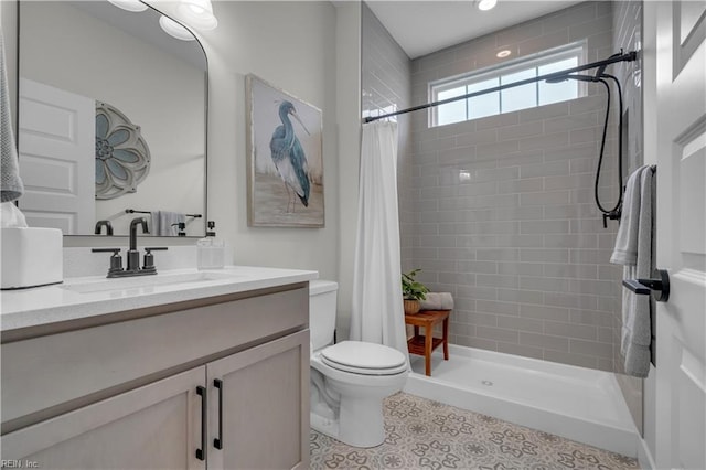 full bathroom with toilet, a shower stall, and vanity