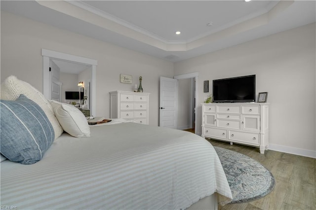 bedroom featuring recessed lighting, dark wood-type flooring, baseboards, a raised ceiling, and crown molding