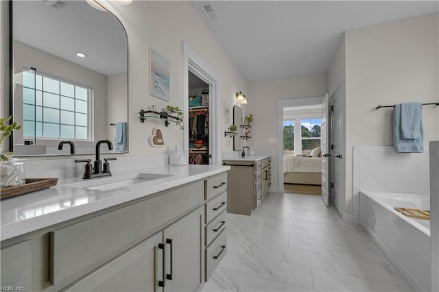 ensuite bathroom with marble finish floor, visible vents, connected bathroom, vanity, and a bath