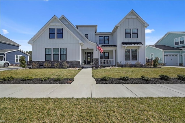 modern inspired farmhouse featuring a garage, metal roof, a standing seam roof, board and batten siding, and a front yard