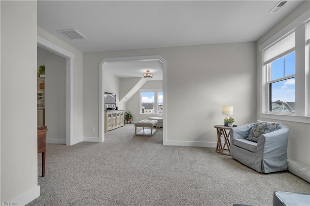 living area with carpet, visible vents, and plenty of natural light