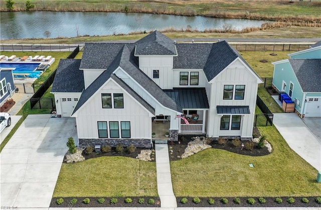 view of front of home featuring board and batten siding, roof with shingles, and a water view