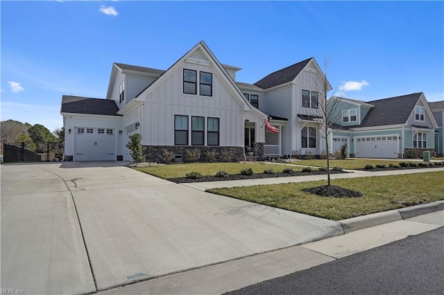 modern inspired farmhouse with a garage, concrete driveway, fence, board and batten siding, and a front yard