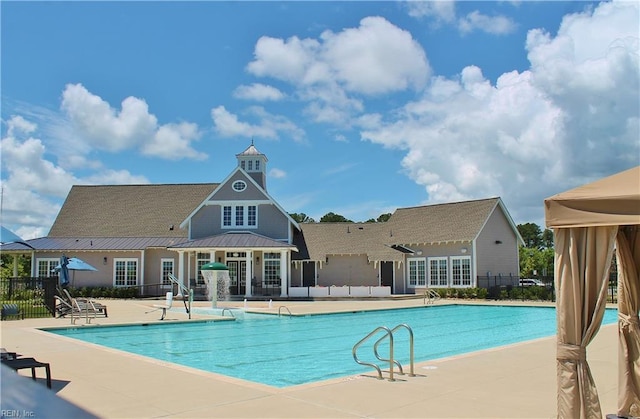 community pool featuring a patio and fence