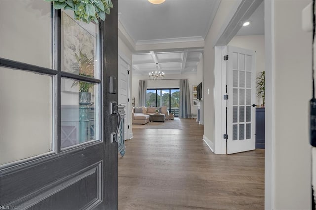 entrance foyer featuring baseboards, coffered ceiling, wood finished floors, a chandelier, and beam ceiling