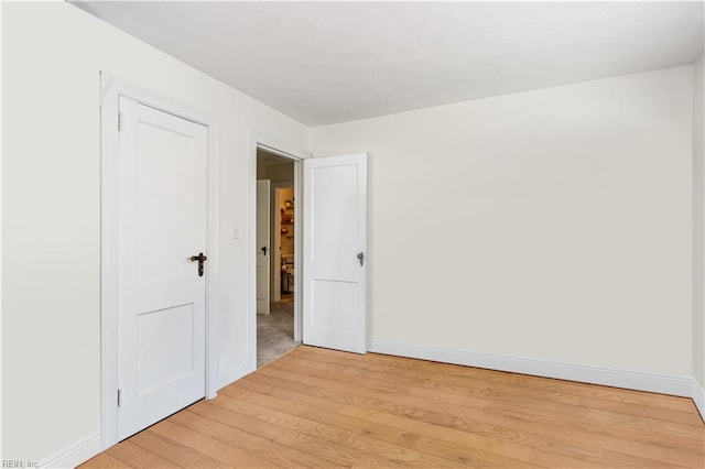 empty room with light wood-type flooring and baseboards