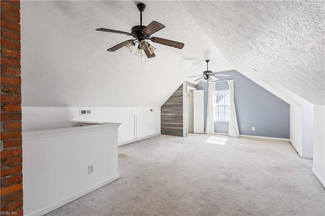 bonus room with lofted ceiling, a textured ceiling, carpet floors, visible vents, and baseboards