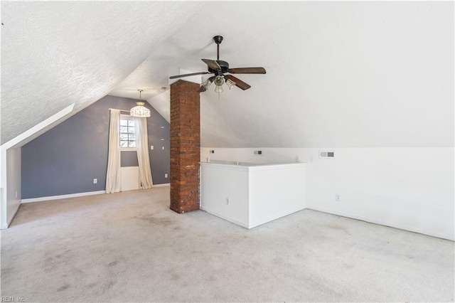 additional living space featuring visible vents, a ceiling fan, carpet flooring, vaulted ceiling, and a textured ceiling