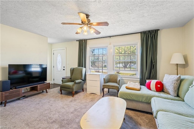 living area featuring a ceiling fan, carpet flooring, and a textured ceiling