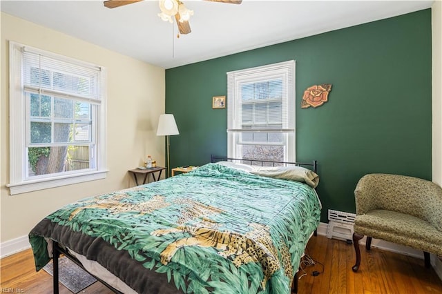 bedroom with ceiling fan, baseboards, and wood finished floors