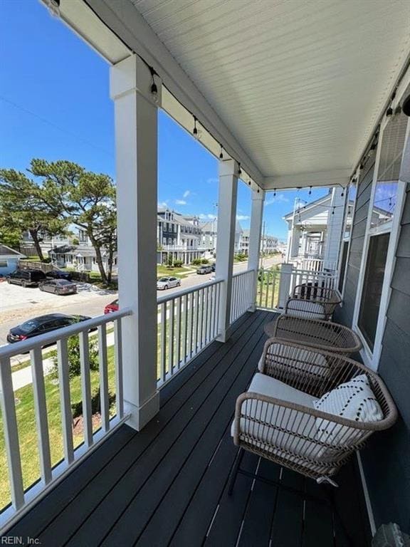 wooden terrace with a residential view and a porch