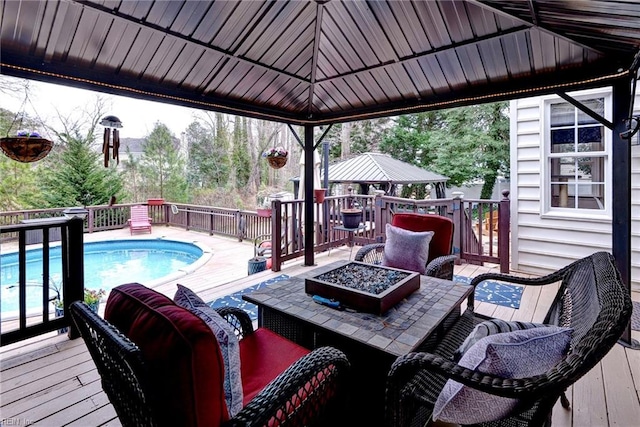 wooden deck featuring a fenced in pool, a fire pit, and a gazebo