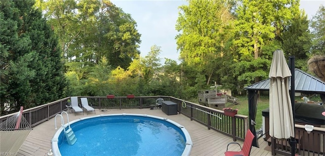 view of swimming pool with a fenced in pool, a gazebo, and a wooden deck