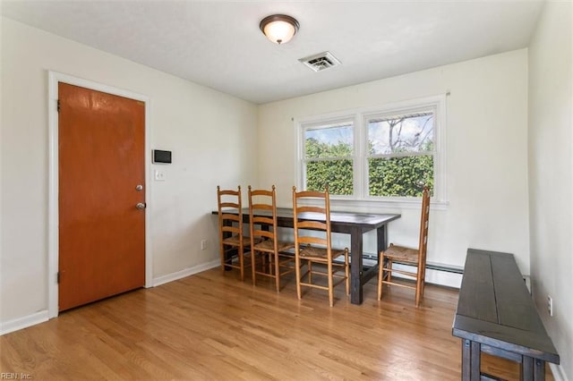 dining area featuring light wood-type flooring, baseboards, and visible vents