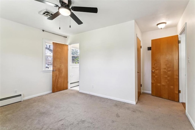 carpeted empty room with a baseboard heating unit, baseboards, and a ceiling fan