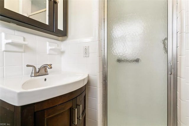 bathroom featuring a stall shower, vanity, and tile walls