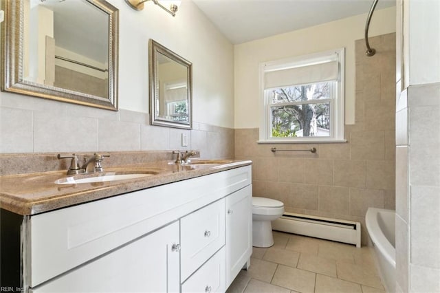 bathroom featuring toilet, tile walls, a baseboard heating unit, and a sink