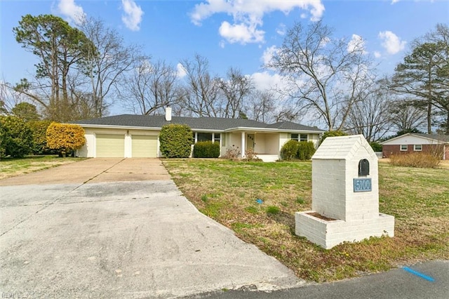 view of front of house featuring a garage, a front yard, concrete driveway, and a chimney