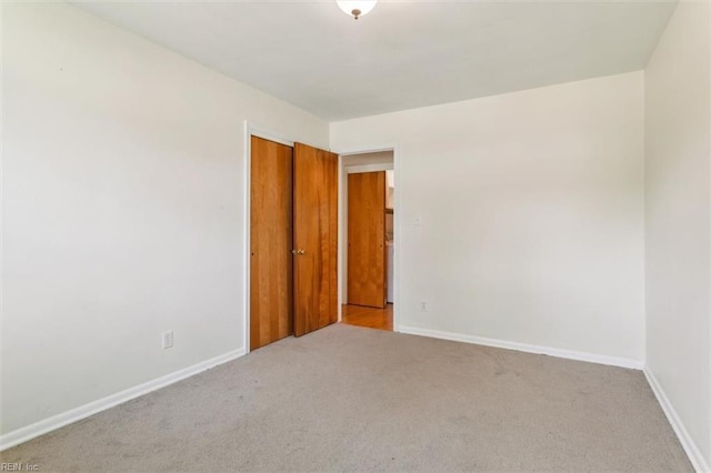 unfurnished room featuring carpet floors and baseboards