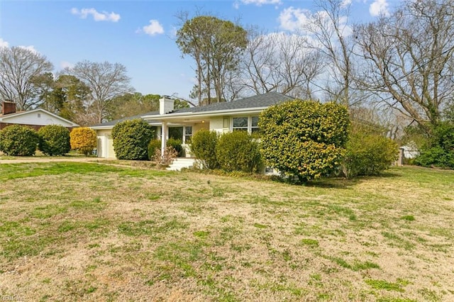 view of front of property featuring a front lawn and a chimney