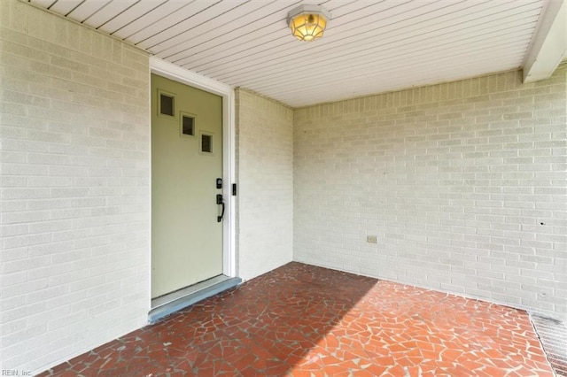 doorway to property with brick siding