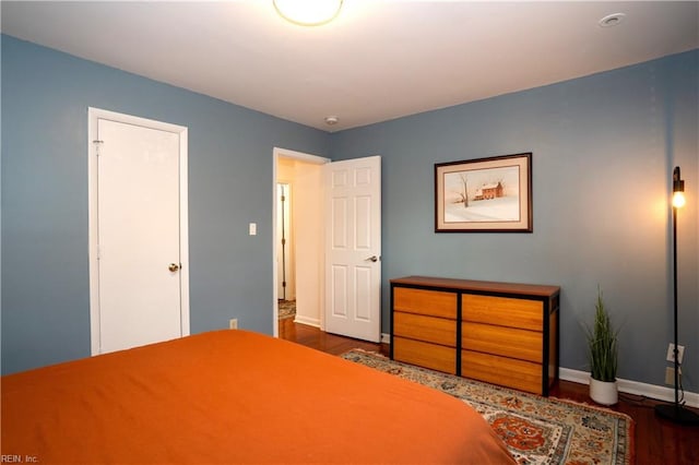 bedroom with baseboards and wood finished floors