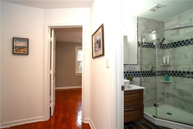 full bathroom featuring a stall shower, visible vents, and wood finished floors