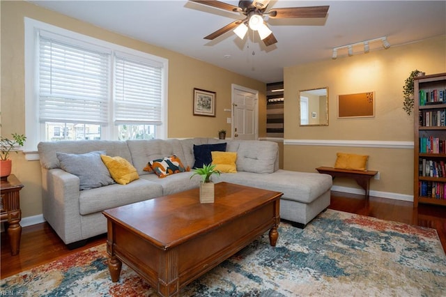 living room featuring ceiling fan, baseboards, and wood finished floors